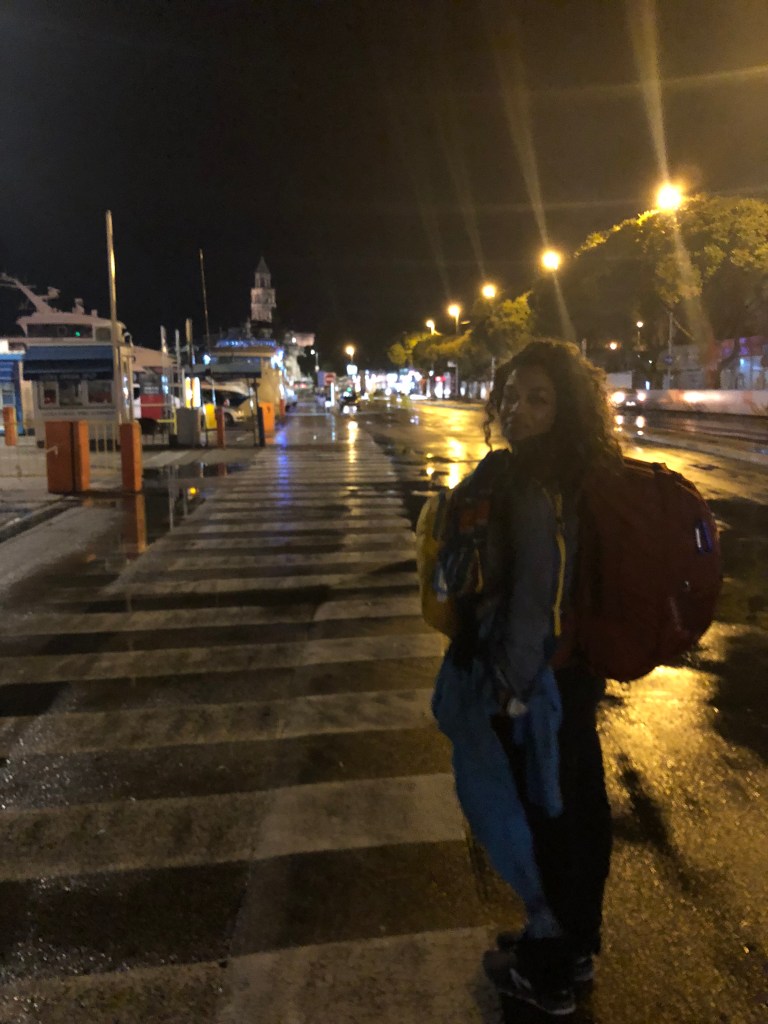 Amanda walking through the streets of Split Croatia with a back packs attached to her chest and back. 